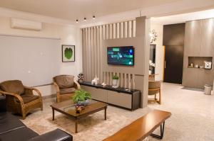 a living room filled with furniture and a flat screen tv at Ville Park Hotel in Ourinhos
