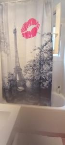 uma cortina de chuveiro com uma imagem da torre Eiffel em 1 Chambre Arena - La Chapelle em Paris