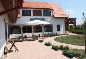 Casa con patio con mesas y sillas en Velocipéd Vendégház, en Balatonudvari