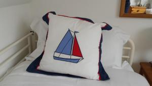 a pillow with a sailboat on it sitting on a bed at 1 Bedroom Apartment with a Wonderful View in Stone