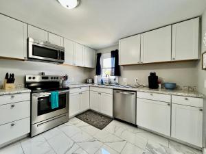 a kitchen with white cabinets and stainless steel appliances at 7086 Tylersville Beautiful 4 BDR Home - Near I-75 in Maud