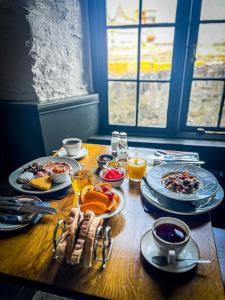 a wooden table with plates of food on it at Rock House Hotel in Lynmouth