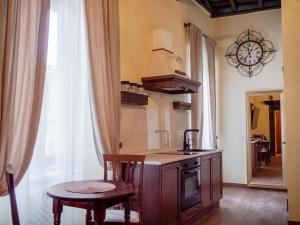 una cucina con un bancone, un lavello e un tavolo di Suite Conte Fernando a Bracciano