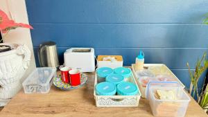 ein Tisch mit Behältern mit Lebensmitteln und einem Toaster in der Unterkunft FRIENDS@SaiLom in Bangkok