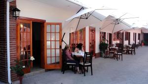 dos mujeres sentadas en una mesa en un patio en Hotel Escorial, en La Serena