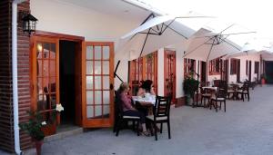 zwei Frauen sitzen an einem Tisch auf einer Terrasse in der Unterkunft Hotel Escorial in La Serena