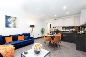 a living room with a blue couch and a kitchen at 4 Beds 2 Bath Stunning Apartment On Street Parking in Brighton & Hove