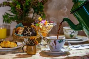 una mesa con tazas de té y una tetera en Petit Casa da Montanha, en Gramado