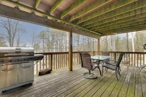 a screened in porch with a stove and a table at Lake George Vacation Rental - Walk to the Water! in Lake George