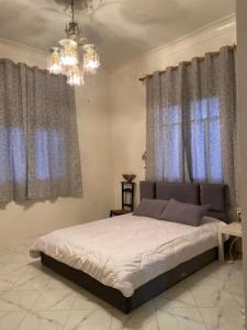 a bedroom with a bed and a chandelier at Marhaba,welcom. in Fès