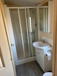 a bathroom with a shower and a sink at Hideout caravan in Llangristiolus