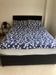 a bed with a blue and white comforter on it at Private room Bishop Norton 
