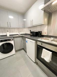 a kitchen with a dishwasher and a washer at Stylish studio on Edgware Road (Marylebone) in London