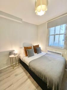 Schlafzimmer mit einem Bett und einem Fenster in der Unterkunft Stylish studio on Edgware Road (Marylebone) in London