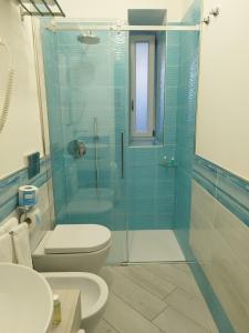 a bathroom with a toilet and a glass shower at SoleMare Rooms "Acquamarina" in Procida