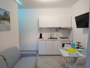 a kitchen with a couch and a table in a kitchen at SoleMare Rooms "Acquamarina" in Procida