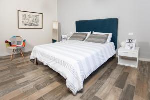 una camera da letto con un grande letto bianco e una sedia di B&B Vignicella a Castelbuono