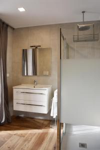 bagno con lavandino bianco e specchio di La Maison Latina Guest House a Latina