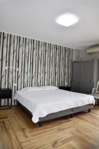 1 dormitorio con cama y pared a rayas en La Maison Latina Guest House, en Latina