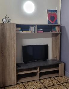 ein Entertainment-Center mit einem Flachbild-TV im Wohnzimmer in der Unterkunft Maison D'AileFine in Tartas