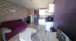 カップ・ダグドにあるNaturiste Port Soleilの紫色のソファ付きのリビングルーム、キッチンが備わります。