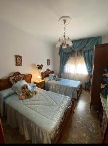 a bedroom with two beds and a teddy bear on the bed at Casa VENTA RUIZO in Lorca