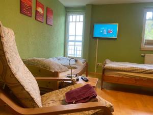 a hospital room with beds and a tv on the wall at Ferienzimmer Oelhaf Zimmer in Grün Self Check-In mit Key-Tresore in Wilhelmsdorf