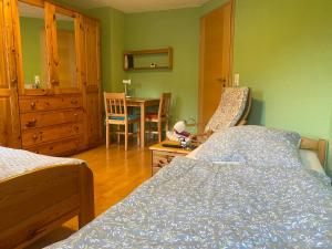een slaapkamer met een bed en een tafel met een stoel bij Ferienzimmer Oelhaf Zimmer in Grün Self Check-In mit Key-Tresore in Wilhelmsdorf