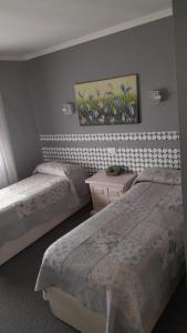 1 dormitorio con 2 camas y un cuadro en la pared en Hotel Monte Carlo Cordoba en Córdoba