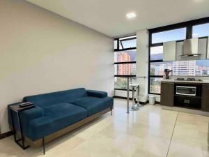 Il comprend un salon avec un canapé bleu et une cuisine. dans l'établissement 2001 Charming apartment in El Poblado, à Medellín