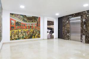 un couloir avec deux grandes peintures sur les murs dans l'établissement 2001 Charming apartment in El Poblado, à Medellín