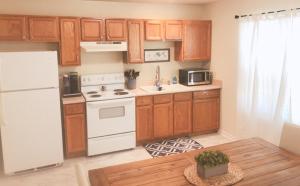 a kitchen with a white refrigerator and wooden cabinets at Landon's Attached Home in Monroe