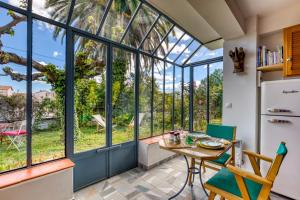 - une cuisine avec de grandes fenêtres, une table et des chaises dans l'établissement Cocooning à Montpellier, à Castelnau-le-Lez