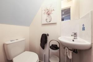 a small bathroom with a toilet and a sink at West Ealing Hububb Stay in Hanwell