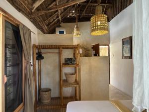 a room with two pendant lights and a shelf at Mlango Paje Villa Boutique in Paje