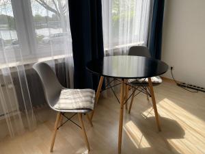 een tafel en 2 stoelen in een kamer met een raam bij Blue 2 in Bremen