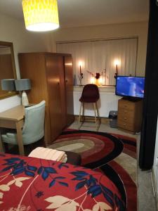 Zimmer mit einem Bett, einem TV und einem Schreibtisch in der Unterkunft Inviting 3-Bed Apartment in Walsall in Walsall