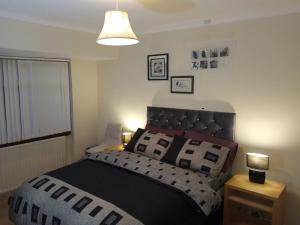 ein Schlafzimmer mit einem Bett und einer Lampe auf einem Tisch in der Unterkunft Inviting 3-Bed Apartment in Walsall in Walsall
