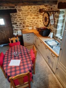 kuchnia ze stołem i umywalką w pokoju w obiekcie Le Gîte De Roseraie w mieście Brécé