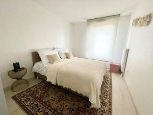 um quarto branco com uma cama e um tapete em Robertsau, jardin en ville em Estrasburgo