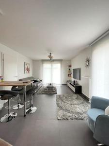 Robertsau, jardin en ville في ستراسبورغ: غرفة معيشة مع طاولة وكراسي وأريكة