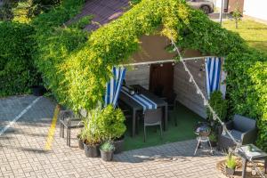 een tuinhuisje met een tafel, stoelen en planten bij Willa Morski Klimat in Łeba