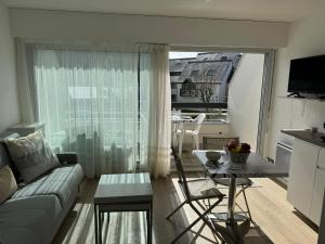 un soggiorno con un divano e un tavolo di Confortable studio, wifi, parking, proche plage a Carnac