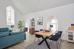 a living room with a table and blue chairs at No 5 Old Church in Ventnor