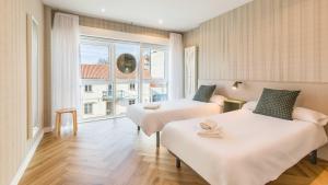 pokój hotelowy z dwoma łóżkami i oknem w obiekcie Pensión 9 de Abril w mieście O Pedrouzo