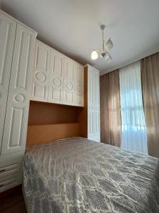a bedroom with a bed and white cabinets at Bulvar Kristal apartment in Sumqayyt