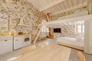 kuchnia i sypialnia z łóżkiem i stołem w obiekcie ArtdecoSyros Superior w mieście Ano Syros