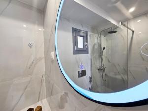 a bathroom with a shower and a large mirror at Sunrise Limnionas Apartments in Marathokampos