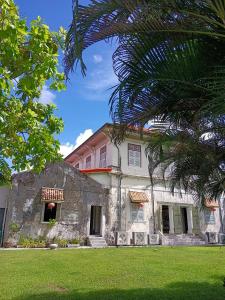 an old stone building in a yard with a tree at Chino Town Gallery Alley - SHA Plus in Phuket Town