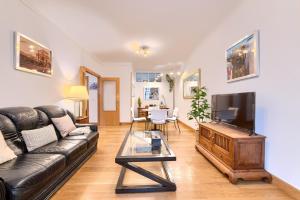 a living room with a couch and a tv at Acogedor y Elegante Apartamento en Irala in Bilbao